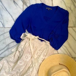 Cool alt blue blouse with v neck and flower patterned cut outs on the arms.